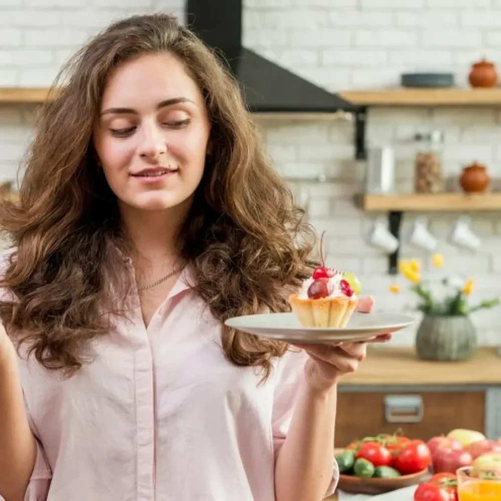 A woman holding a light, healthy dessert in her kitchen